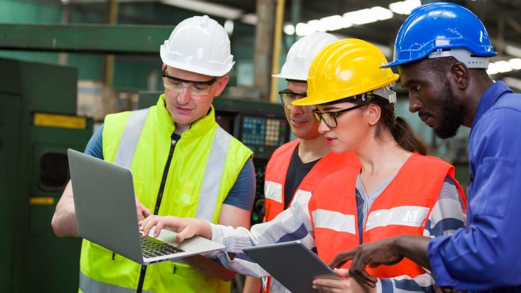 Plant team in PPE reviewing a laptop and tablet, showing why the wrong training problem starts with workplace application.